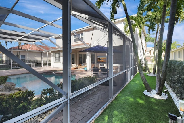 exterior space with glass enclosure, a yard, and a patio