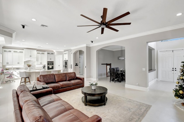 living room featuring ceiling fan and crown molding