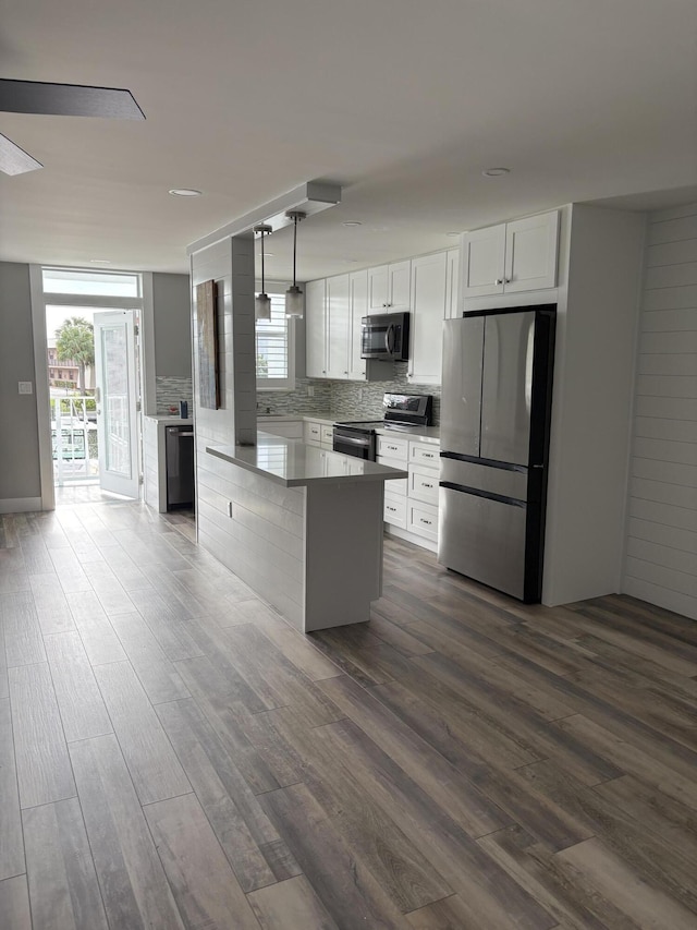 kitchen featuring pendant lighting, dark hardwood / wood-style floors, white cabinetry, and stainless steel appliances