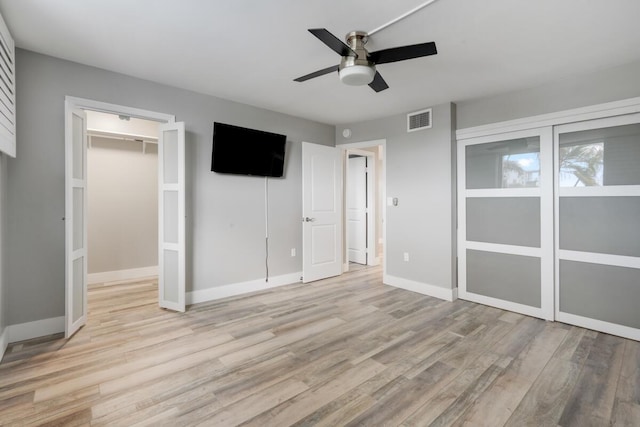 unfurnished bedroom with baseboards, visible vents, a ceiling fan, light wood-style flooring, and a closet