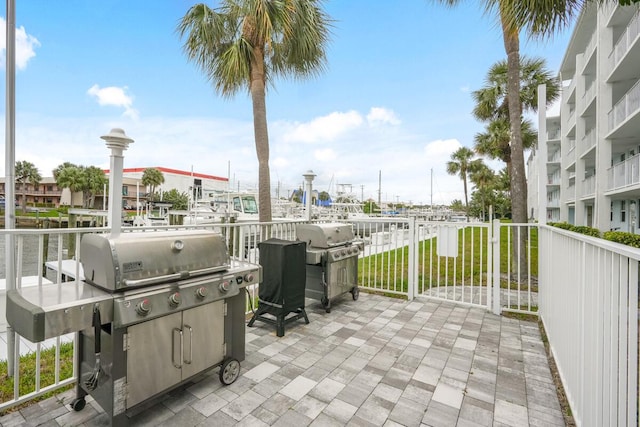 view of patio featuring a water view and grilling area