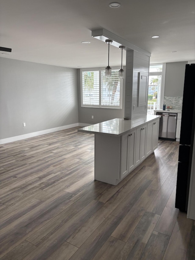 kitchen featuring stainless steel dishwasher, decorative light fixtures, white cabinetry, and a wealth of natural light