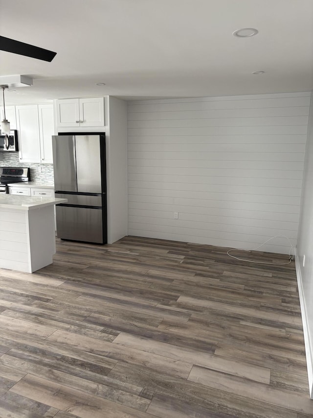 kitchen featuring dark hardwood / wood-style flooring, white cabinetry, hanging light fixtures, and appliances with stainless steel finishes