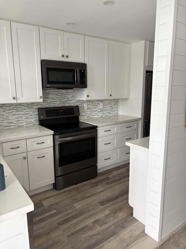 kitchen with electric range, dark hardwood / wood-style flooring, white cabinetry, and backsplash