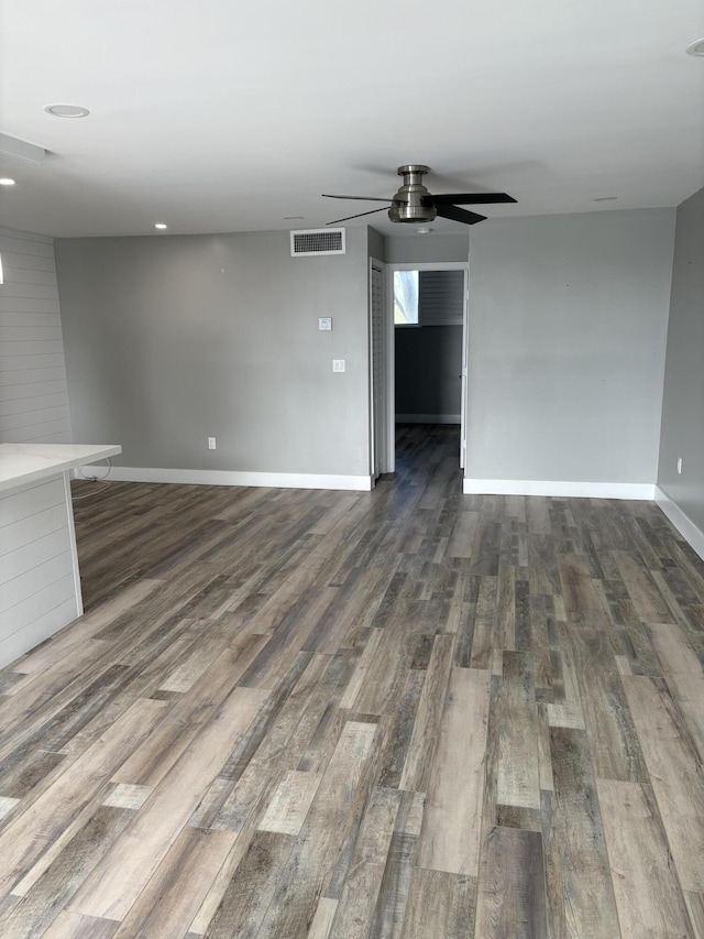 unfurnished living room with dark hardwood / wood-style floors and ceiling fan