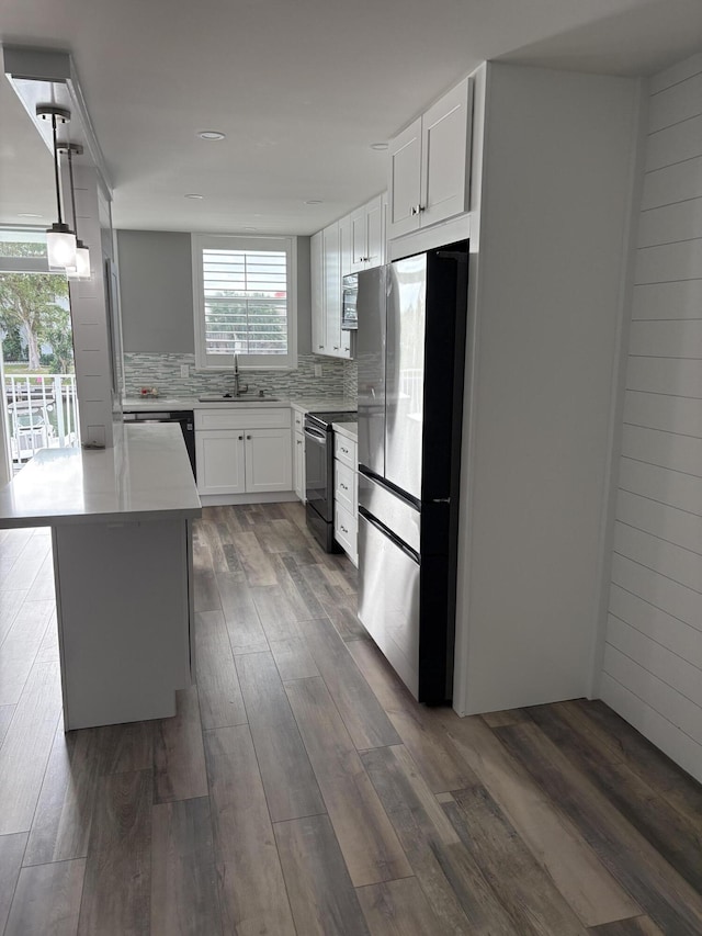 kitchen featuring white cabinets, a kitchen island, appliances with stainless steel finishes, and tasteful backsplash