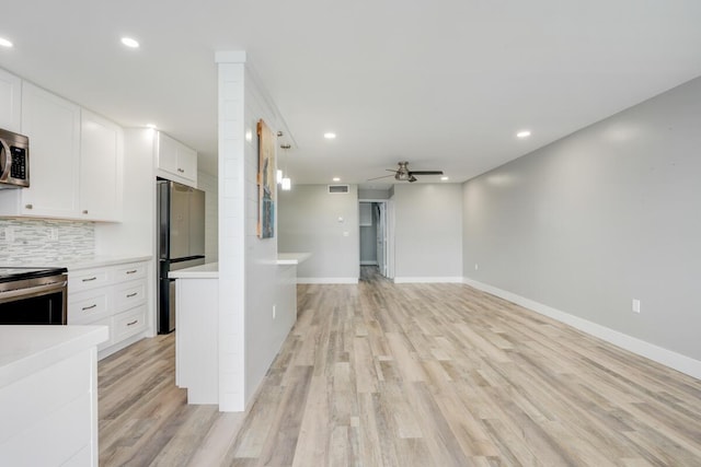 kitchen featuring stainless steel appliances, white cabinets, light countertops, and ceiling fan