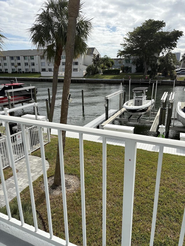 view of dock with a water view and a yard