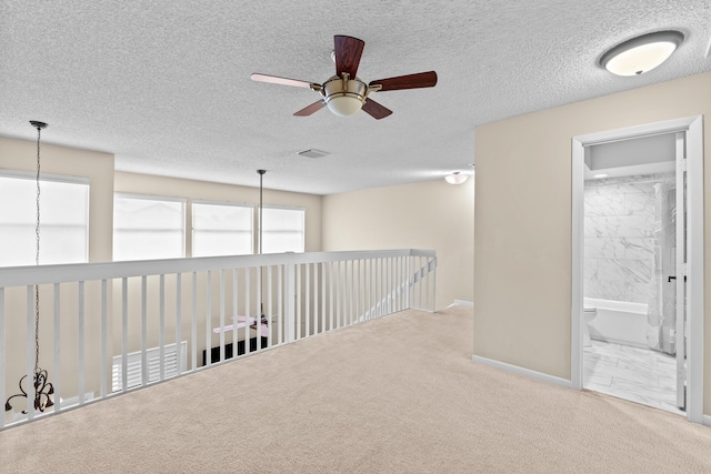 hall featuring carpet and a textured ceiling