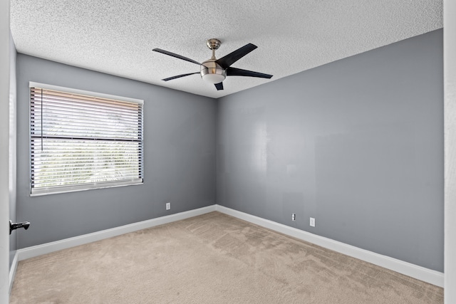 carpeted empty room with ceiling fan and a textured ceiling