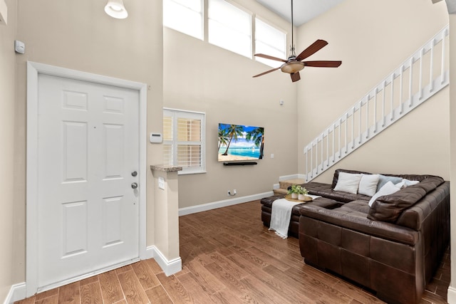 entrance foyer with a towering ceiling, hardwood / wood-style flooring, and ceiling fan