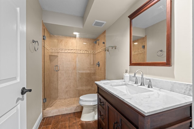 bathroom with walk in shower, vanity, and toilet