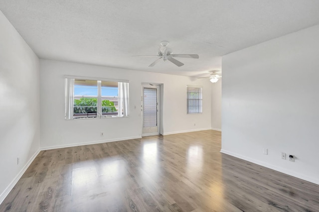 spare room featuring hardwood / wood-style flooring, ceiling fan, and a textured ceiling