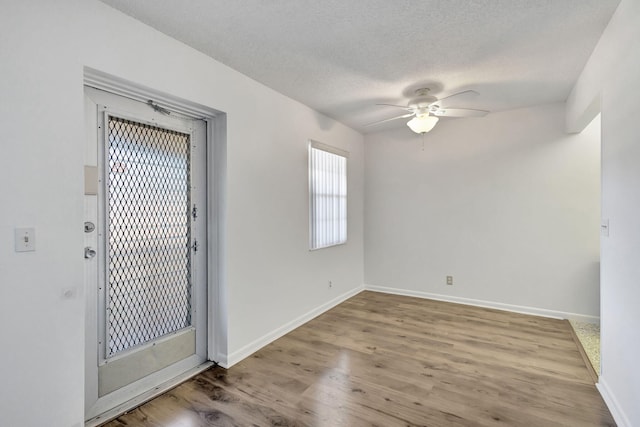 interior space with ceiling fan, a textured ceiling, and light hardwood / wood-style flooring