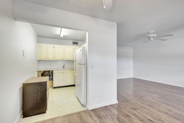 kitchen with ceiling fan, white fridge, sink, and light hardwood / wood-style flooring