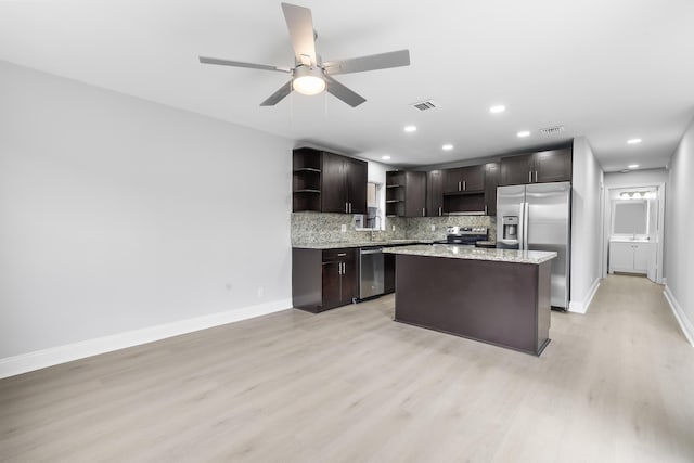 kitchen with appliances with stainless steel finishes, tasteful backsplash, dark brown cabinetry, ceiling fan, and light hardwood / wood-style floors