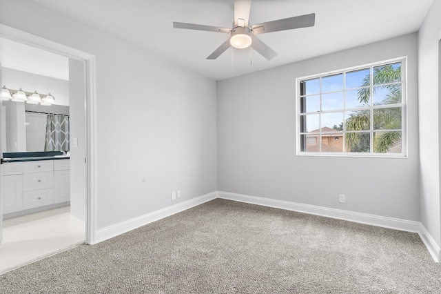 unfurnished room with ceiling fan and carpet