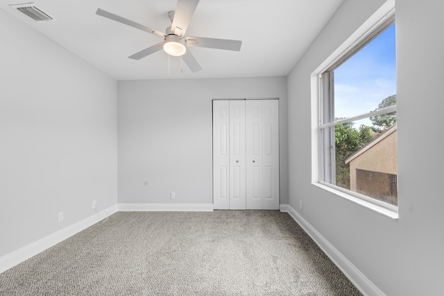 unfurnished bedroom featuring carpet flooring, a closet, and ceiling fan