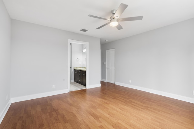 unfurnished bedroom featuring ceiling fan, light hardwood / wood-style flooring, and ensuite bath