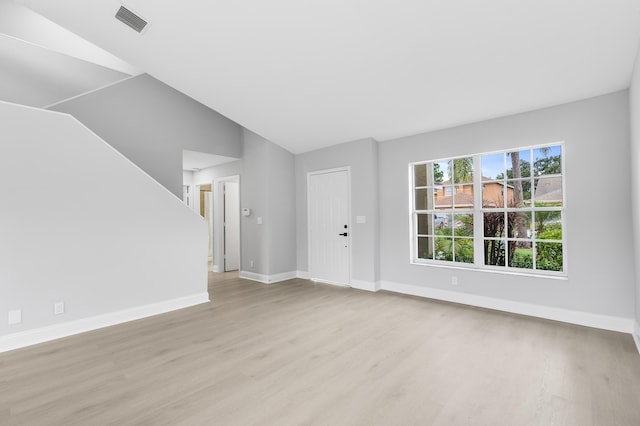 unfurnished living room with light hardwood / wood-style flooring and vaulted ceiling