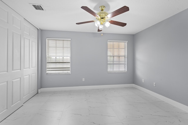 spare room featuring ceiling fan and a healthy amount of sunlight