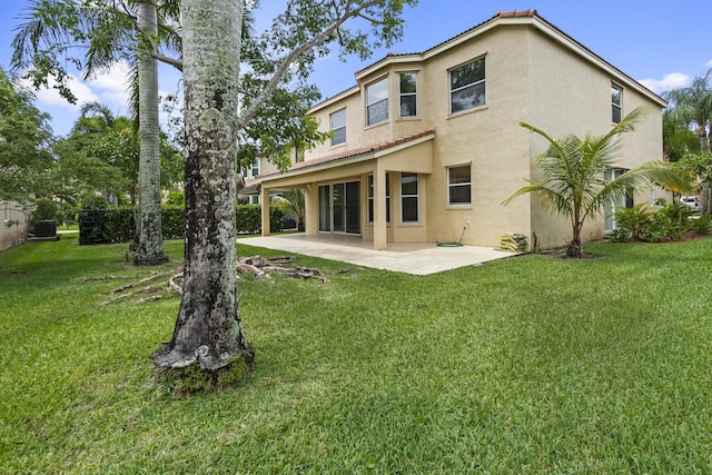 rear view of house with a patio and a lawn