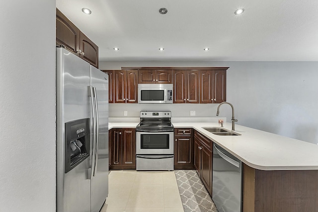 kitchen with kitchen peninsula, sink, stainless steel appliances, and dark brown cabinets