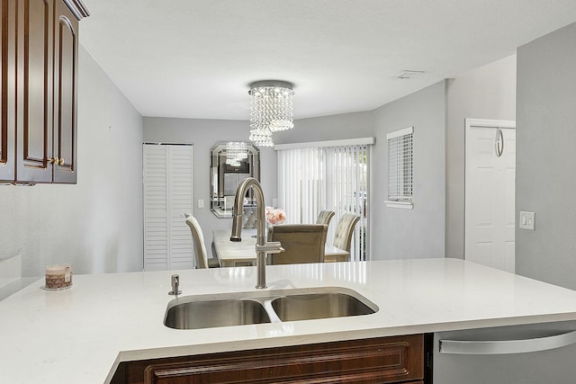 kitchen with dishwasher, a notable chandelier, and sink