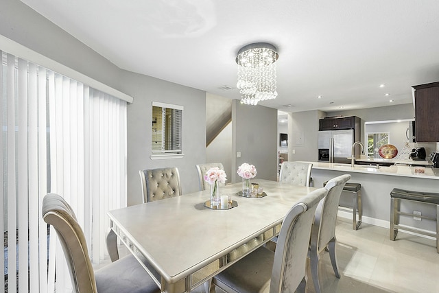 dining room featuring sink and a notable chandelier