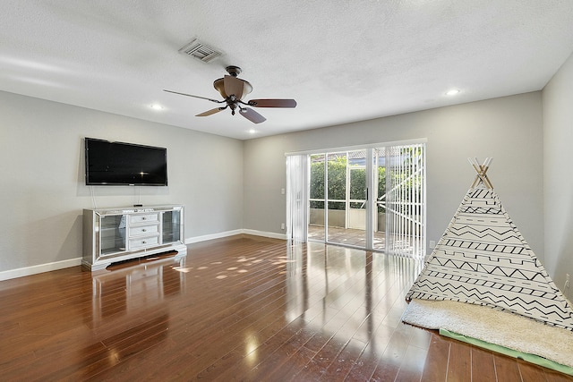 playroom featuring ceiling fan, wood-type flooring, and a textured ceiling