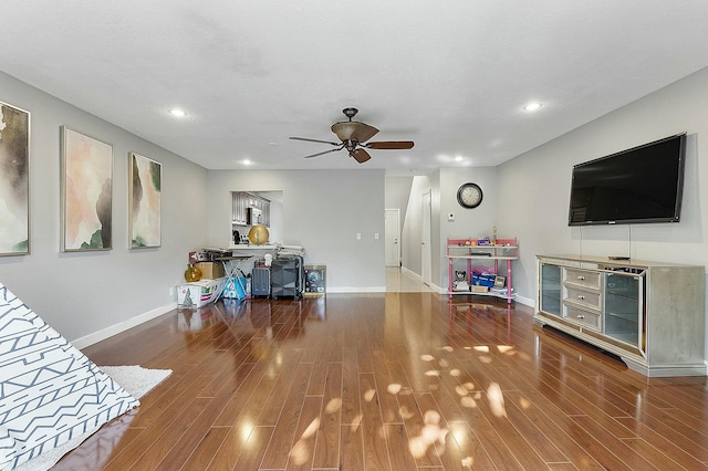 living room featuring ceiling fan, hardwood / wood-style floors, and a textured ceiling