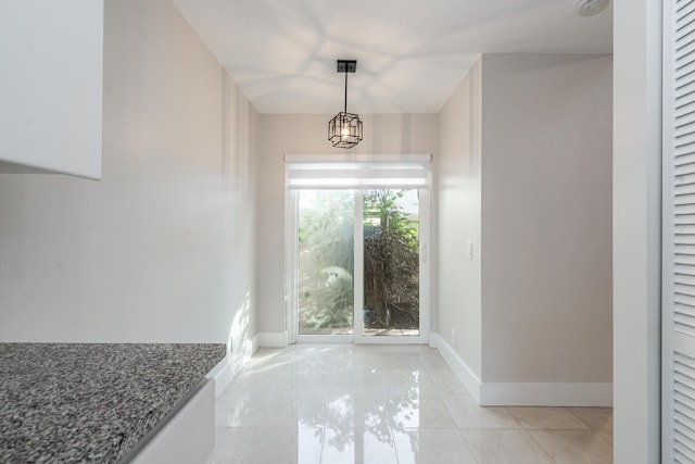 foyer entrance featuring light tile patterned flooring and a notable chandelier