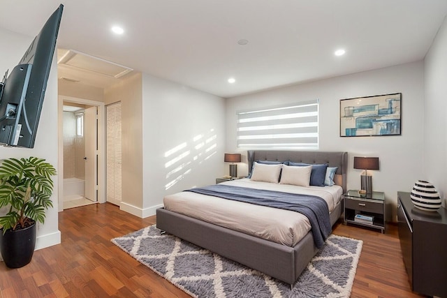 bedroom featuring dark hardwood / wood-style flooring and ensuite bath