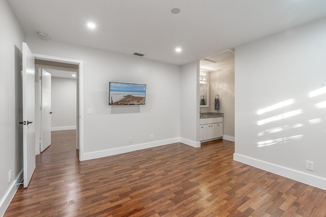 unfurnished bedroom with dark wood-type flooring and connected bathroom