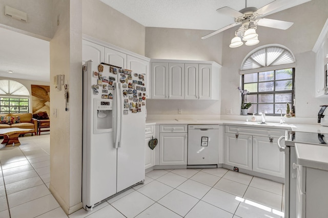 kitchen featuring light tile patterned floors, white appliances, white cabinetry, and sink