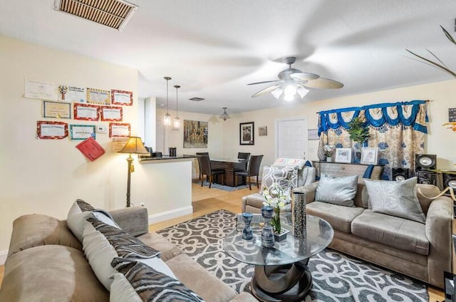 living room with ceiling fan and light wood-type flooring