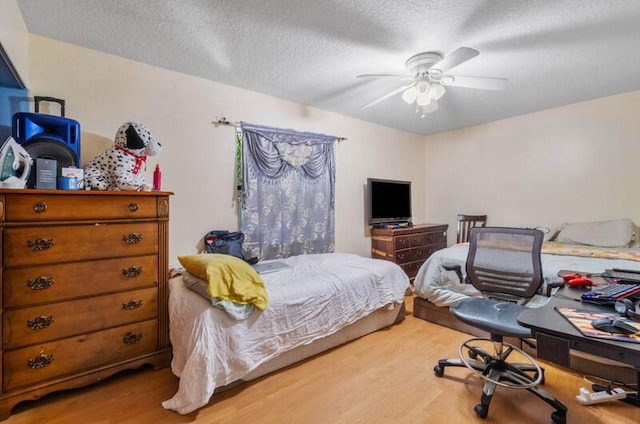 bedroom with wood-type flooring, a textured ceiling, and ceiling fan