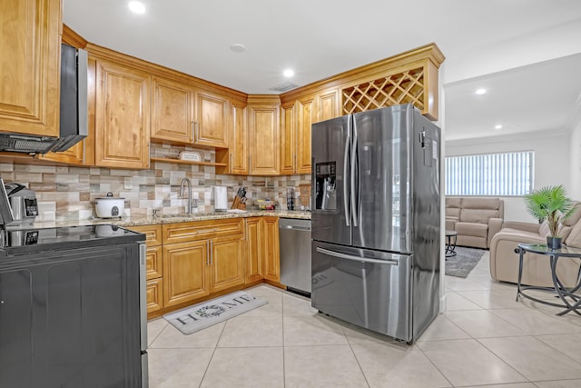 kitchen with light tile patterned flooring, appliances with stainless steel finishes, light stone counters, and sink