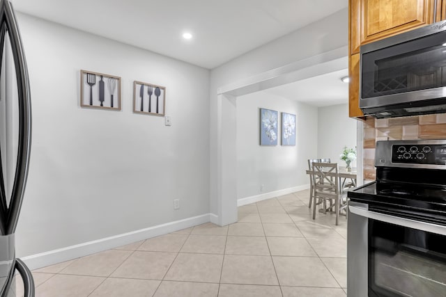 kitchen with electric range and light tile patterned floors