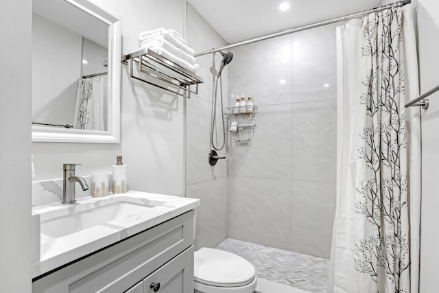 bathroom with walk in shower, vanity, and toilet