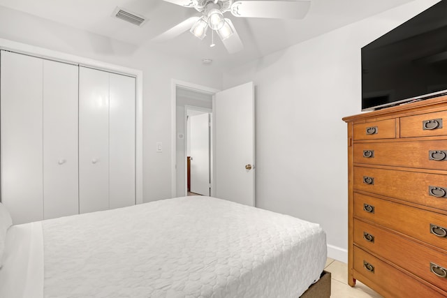 bedroom featuring ceiling fan, a closet, and light tile patterned floors