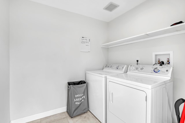 laundry room featuring light tile patterned floors and separate washer and dryer