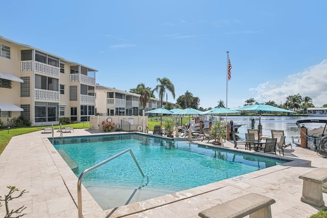 view of pool featuring a patio area and a water view