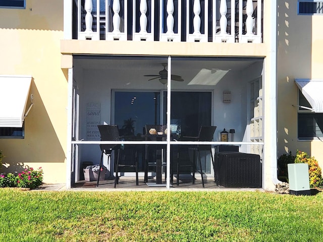 back of property with ceiling fan, a patio area, a balcony, and a yard