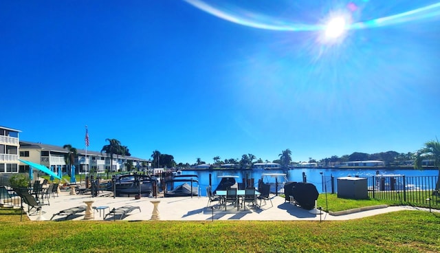 exterior space with a lawn, a grill, and a water view