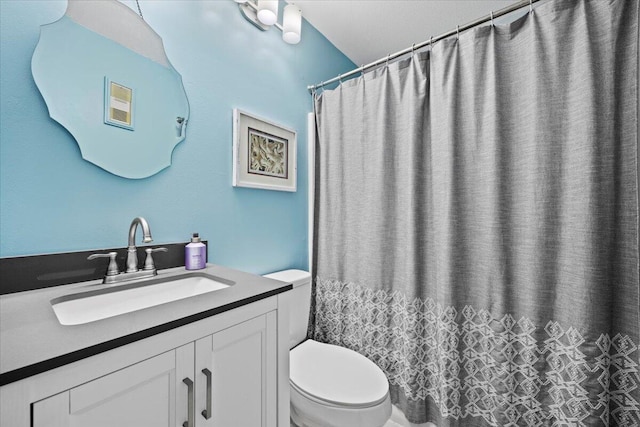 bathroom with vanity, curtained shower, and toilet