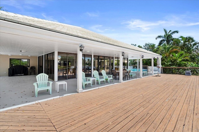 wooden deck featuring area for grilling and a swimming pool