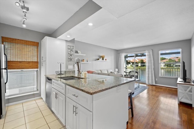 kitchen with white cabinetry, light stone countertops, sink, kitchen peninsula, and appliances with stainless steel finishes