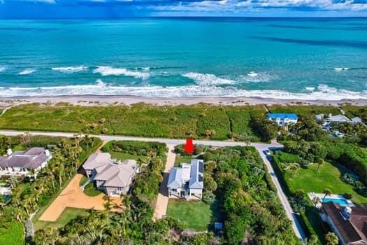 birds eye view of property featuring a water view and a beach view