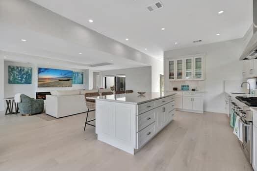 kitchen with a breakfast bar area, high end stove, white cabinetry, and a kitchen island